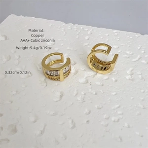 Close-up of 18k gold plated copper earrings with AAA+ cubic zirconia on a stone stand