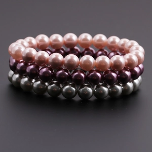 Détail d'un bracelet multicouche perlé avec des perles roses, mauves et grises