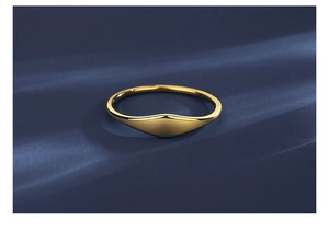 Detailed macro view of a polished gold minimalist ring on deep blue velvet background