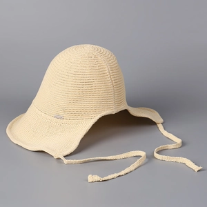 Detail of breathable beige knit sun hat with wavy brim and metallic logo emblem