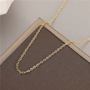 Minimalist 1.5mm gold thin cable chain necklace on a textured brown gift box