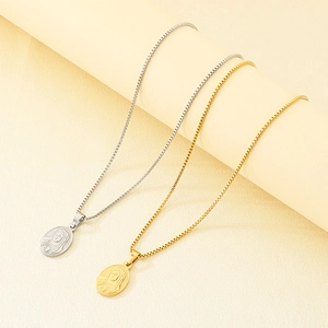 Detailed close-up of oval Virgin Mary pendants in gold and silver stainless steel finishes