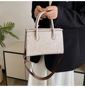 Detail of cream white faux leather handbag with vintage crackle texture and wide strap