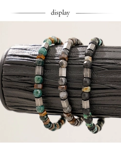 Close-up of faceted tiger eye and onyx beaded bracelets with metal square spacers