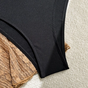 Detailed close-up of vertical ribbed fabric stitched with delicate brown floral lace pattern