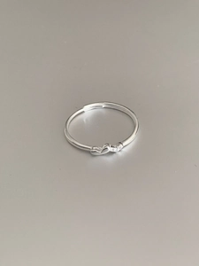 Detailed close-up of a delicate silver heart ring with sparkling crystal inlay