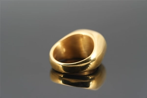 Macro side view of a polished gold chunky dome ring showing smooth mirror reflections