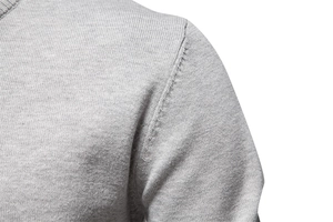 Détail de la couture d'épaule sur un pull en maille de coton gris pour homme