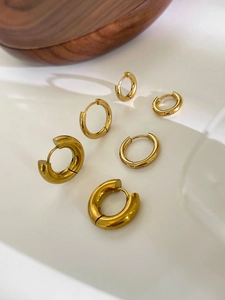 Three pairs of golden stainless steel hoop earrings in various thicknesses and sizes
