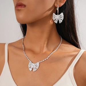 Dettaglio del set collana e orecchini a fiocco in zircone argento su una modella