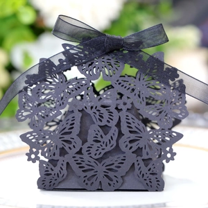 Detail showing laser-cut butterfly patterns and black ribbon on an elegant gift box