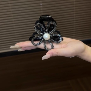 Detailed shot of sunflower hair claw clip with grey rhinestones and a large center pearl