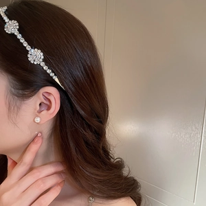 Cerchietto con cristalli e foglie e orecchini di perle indossati da una modella