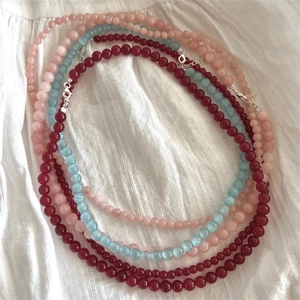 Detail of red agate and pink quartz beaded necklaces with silver spring clasps