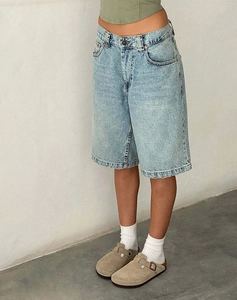 Detail shot of light blue vintage wash denim shorts with a slim fit on a female model