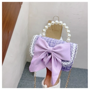 Detail of purple tweed girls handbag with pearl handle and large bow decoration