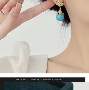 Close-up of ethnic turquoise drop earrings featuring gold hollow metal and blue bead
