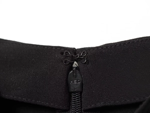 Close-up of black sleeveless top showing waist zipper closure and metallic HED hook detail