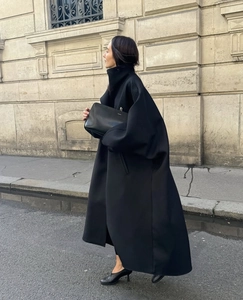 Détail d'un trench-coat noir long oversize en laine avec un col montant chic