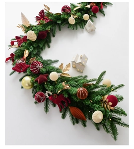 Detail of Christmas velvet garland with ornaments, LED lights and festive pine needles