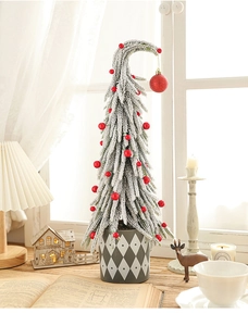 Miniature snow-dusted Christmas tree with red berries in a grey geometric base