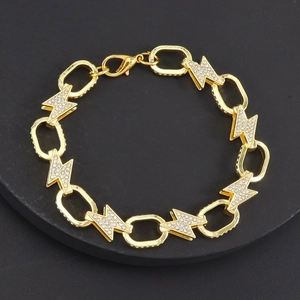 Gold lightning bolt chain bracelet with sparkling crystals on a black pedestal