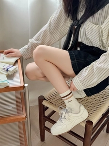 Detail view of mid-calf sports socks with double stripes and Smile embroidery in beige