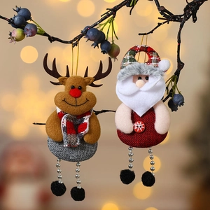 Christmas reindeer and Santa fabric ornaments hanging on tree branches with warm bokeh lights