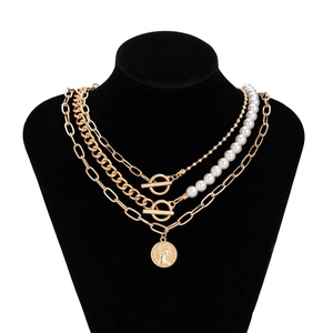 Detail of baroque pearl multilayer necklace with coin pendant and golden toggle clasp