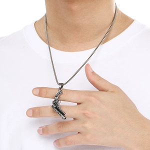 Detailed close-up of a silver stainless steel revolver pistol pendant necklace for men