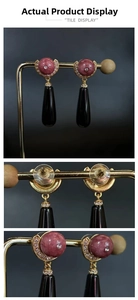 Detailed view of vintage long drop earrings with pink marble bead and black teardrop pendant