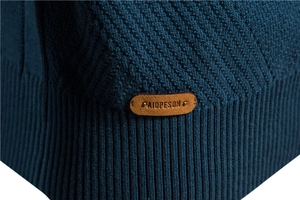 Macro view of navy knit texture with premium brown leather brand patch detail