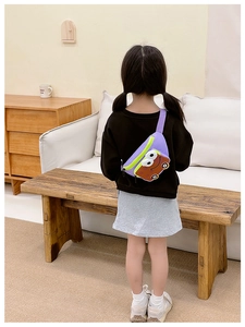 Child wearing purple cartoon car crossbody bag with vibrant green zipper outdoors