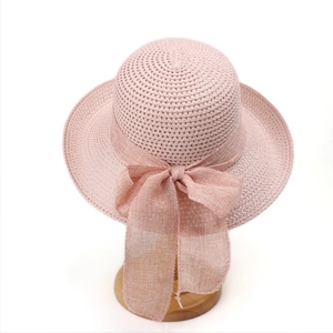 Detailed macro of pink straw sun hat featuring a lightweight large bow decoration