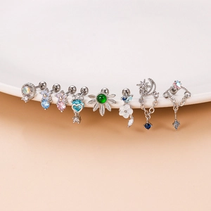 Colorful zircon flower and butterfly stainless steel earrings set on a white ceramic tray