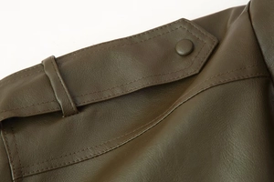 Detailed view of dark brown leather jacket shoulder with epaulette and button detail