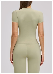 Rear view of slim fit sage green short sleeve yoga top and matching leggings