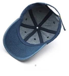 Inside view of navy denim baseball cap showing six-panel stitching and metal buckle strap