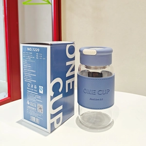 Blue glass tea infuser bottle with packaging showing material specifications