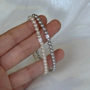 Detailed view of dainty pearl bracelets featuring a sparkling center zircon stone