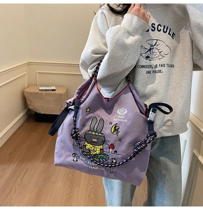 Close-up of purple canvas tote bag with cartoon rabbit and blue braided rope straps