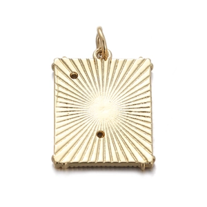 Detailed view of a gold rectangular charm with celestial radial texture and dual holes