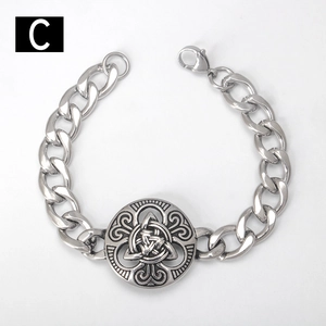 Macro shot of Celtic knot relief on silver curb chain punk bracelet for men