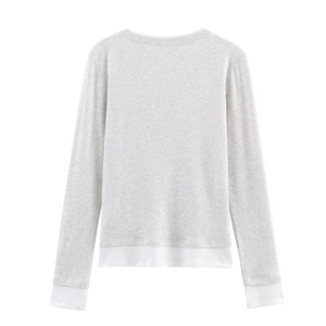 Detail view of grey crewneck sweatshirt with white contrast stitching on hem and cuffs