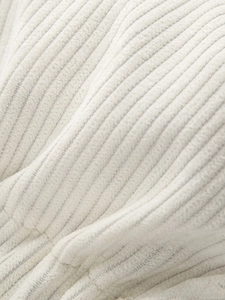 Macro shot of soft off-white corduroy fabric texture showing vertical ribbed patterns