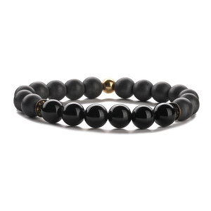 Elastic beaded bracelet with matte black stone beads and a single gold accent bead