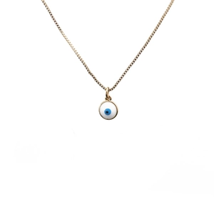Dettaglio della collana dorata con ciondolo malocchio in smalto bianco e centro blu