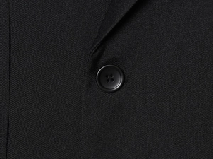 Macro detail of high-quality black twill fabric and matte resin button on women suit set