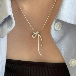 Minimalist 925 silver two-tone bow knot necklace worn on a lifestyle model shot