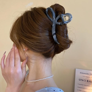 Detail of grey marble pattern hair claw clip styled on a professional bun hairstyle